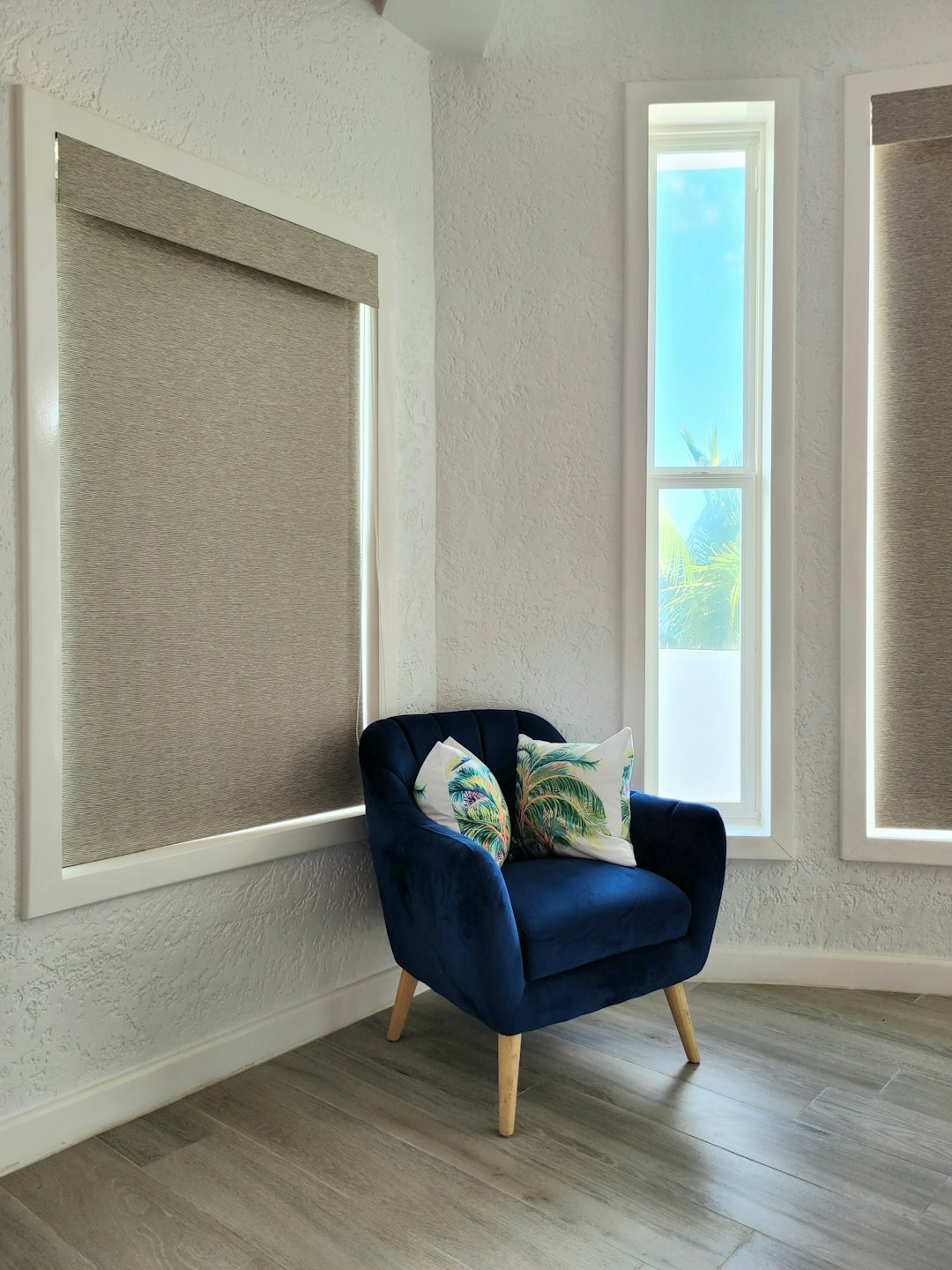 a-blue-chair-sitting-in-front-of-a-window-bmd7lfnsrlk